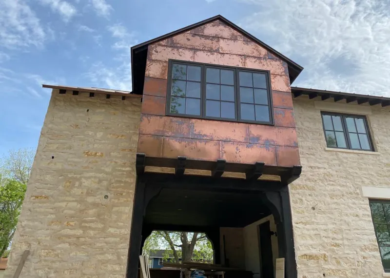 Copper metal panel facade on a stone building for Roof Repair in West Fargo